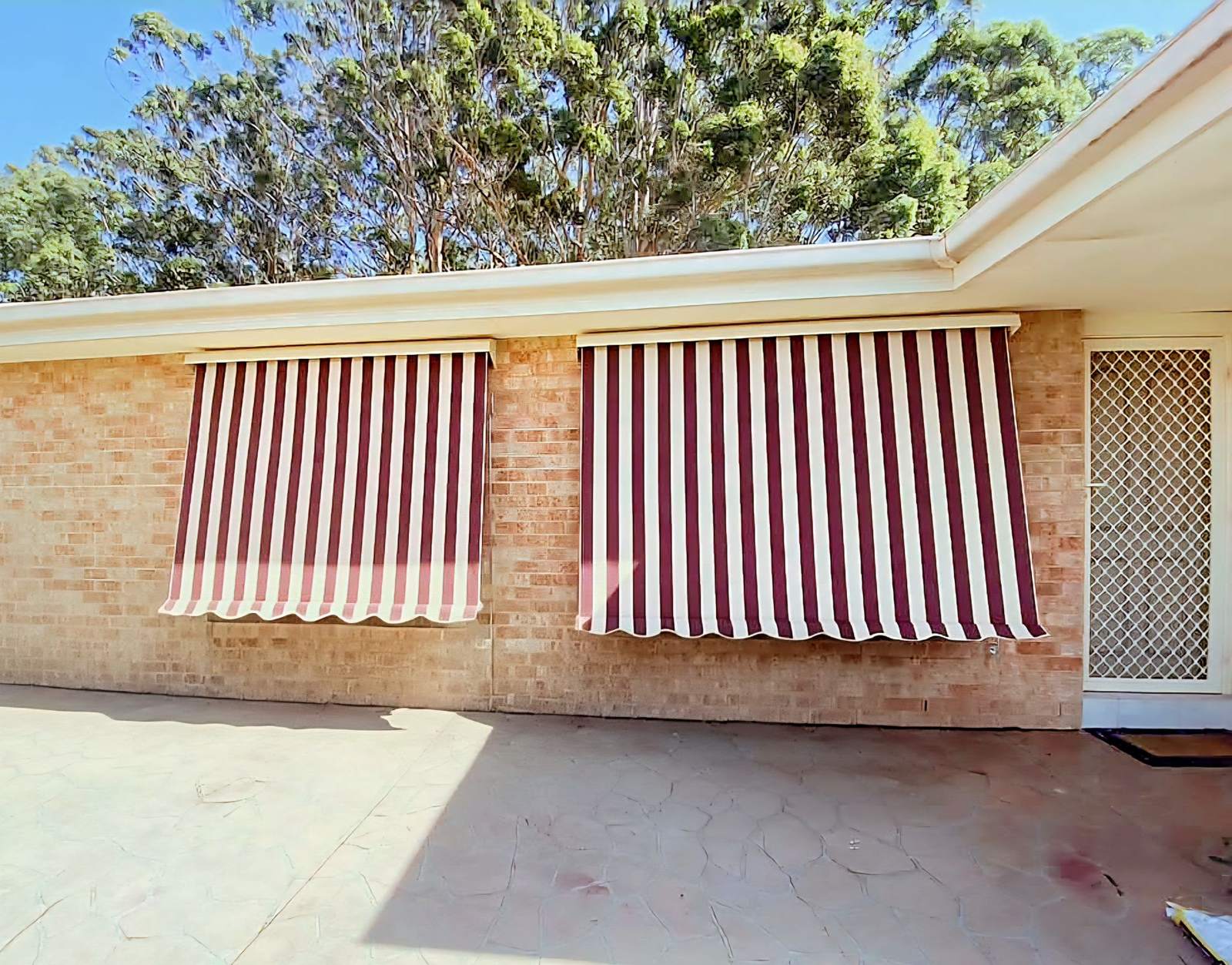 Striped automatic awnings on a brick home in Edgeworth